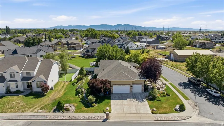 Expansive residential property with an attached two-car garage, concrete driveway, and mature landscaping