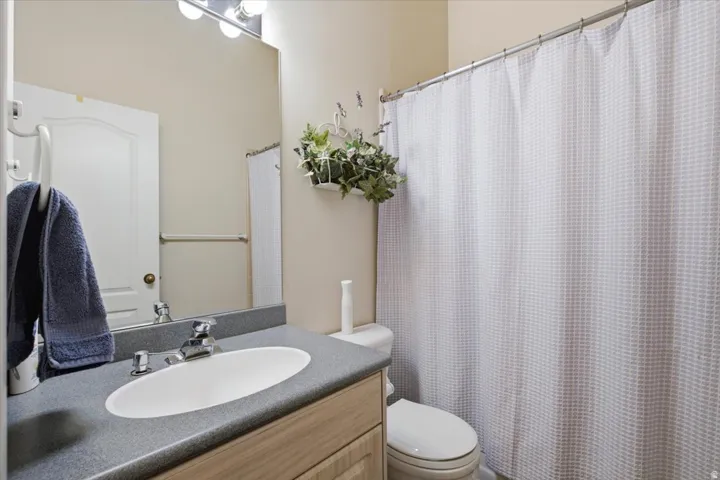 Built-in vanity with an oval basin sink, chrome faucet, and gray countertop