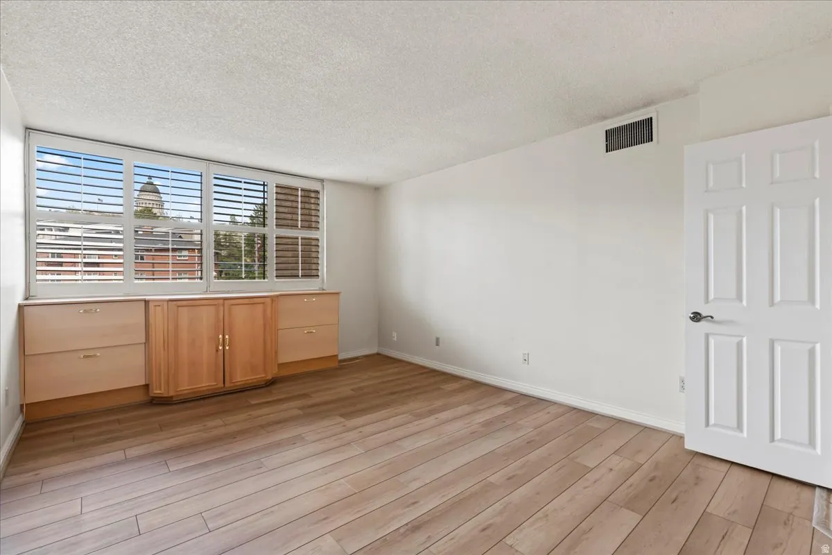 Wood-finish flooring, built-in cabinetry, custom window shutters, and a classic six-panel door