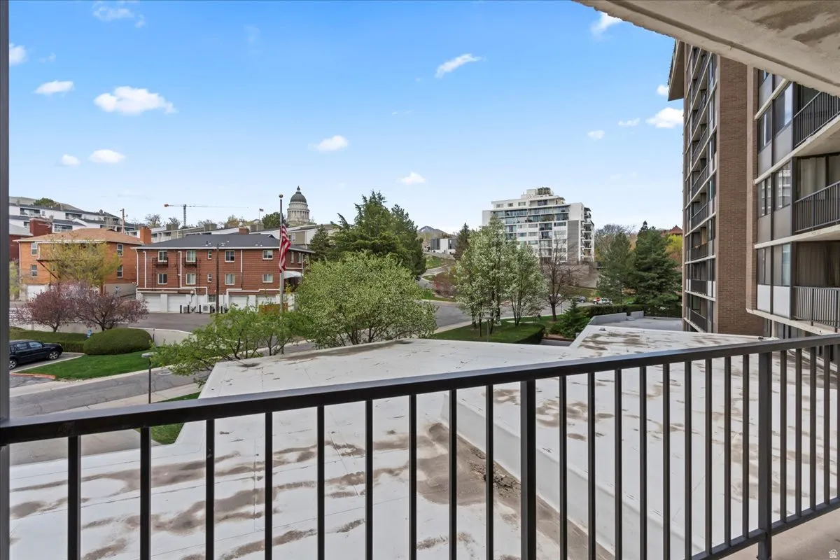 Balcony featuring black metal railings and overhead concrete