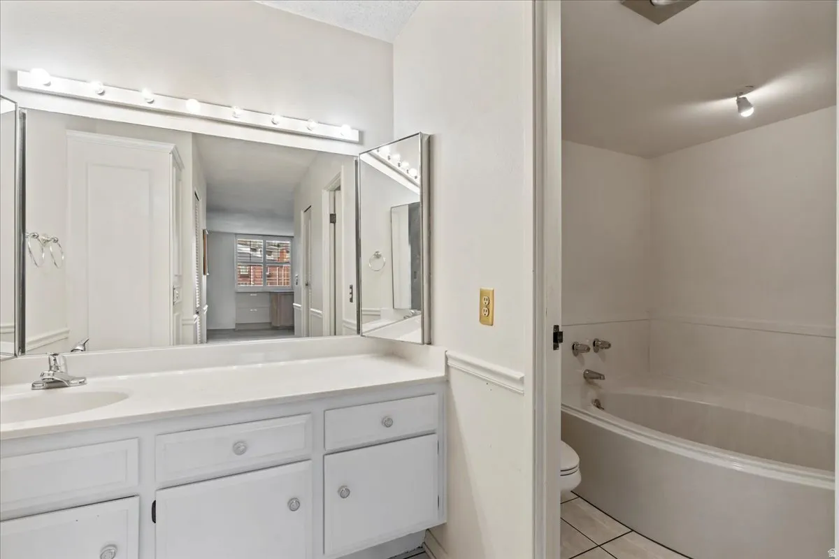 White vanity with integrated sink, chrome faucet, and triptych mirror