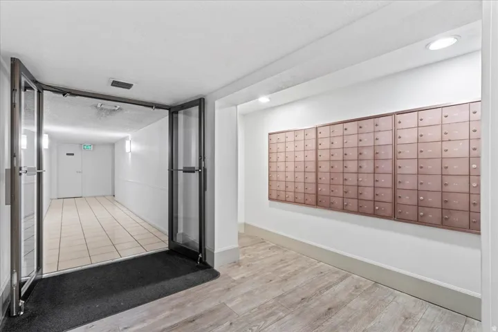Laminate wood-finish flooring, recessed lighting, and wall-mounted mailboxes