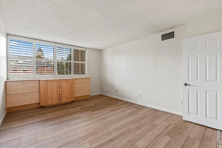 Wood-finish flooring, built-in cabinetry, custom window shutters, and a classic six-panel door