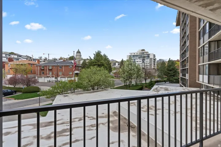 Balcony featuring black metal railings and overhead concrete