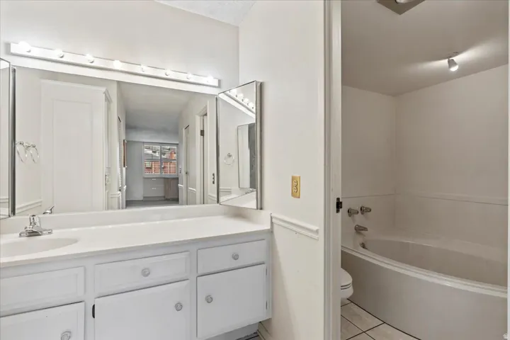 White vanity with integrated sink, chrome faucet, and triptych mirror