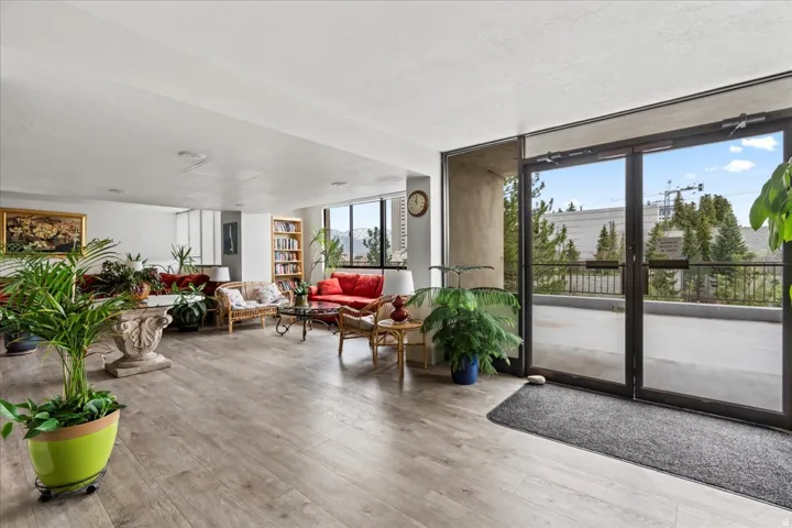 Spacious common area featuring wood-finish flooring, extensive natural light, large pane windows, and a built-in bookshelf