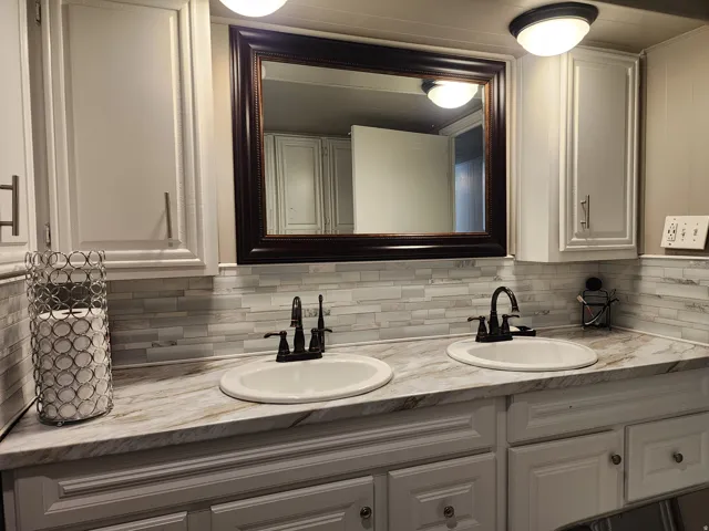 Dual undermount sinks with bronze-finish faucets, set into a stone-finish countertop