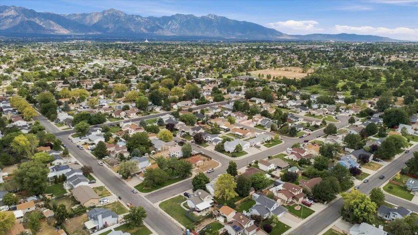 Residential area with extensive tree canopy and mountain backdrop