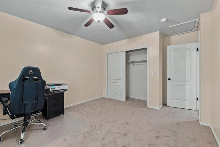 Spacious bedroom with neutral wall finishes, carpet flooring, and abundant natural light from recessed ceiling fixtures
