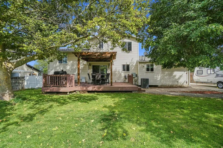 Spacious two-story residence with a generous backyard featuring mature shade trees and expansive lawn