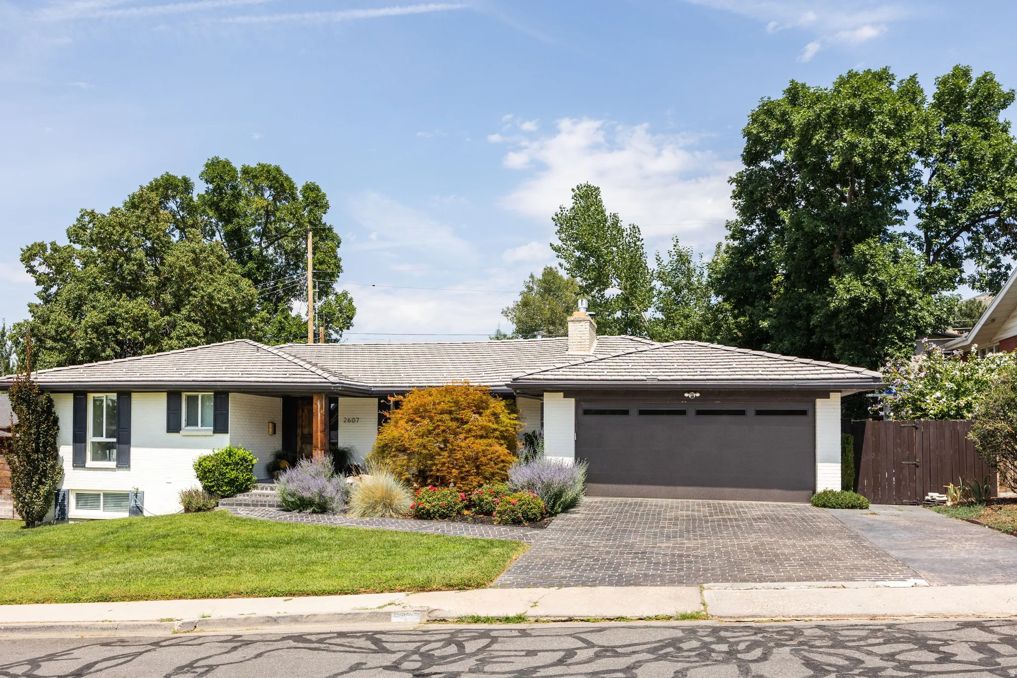 White exterior with black window shutters and a gray garage door