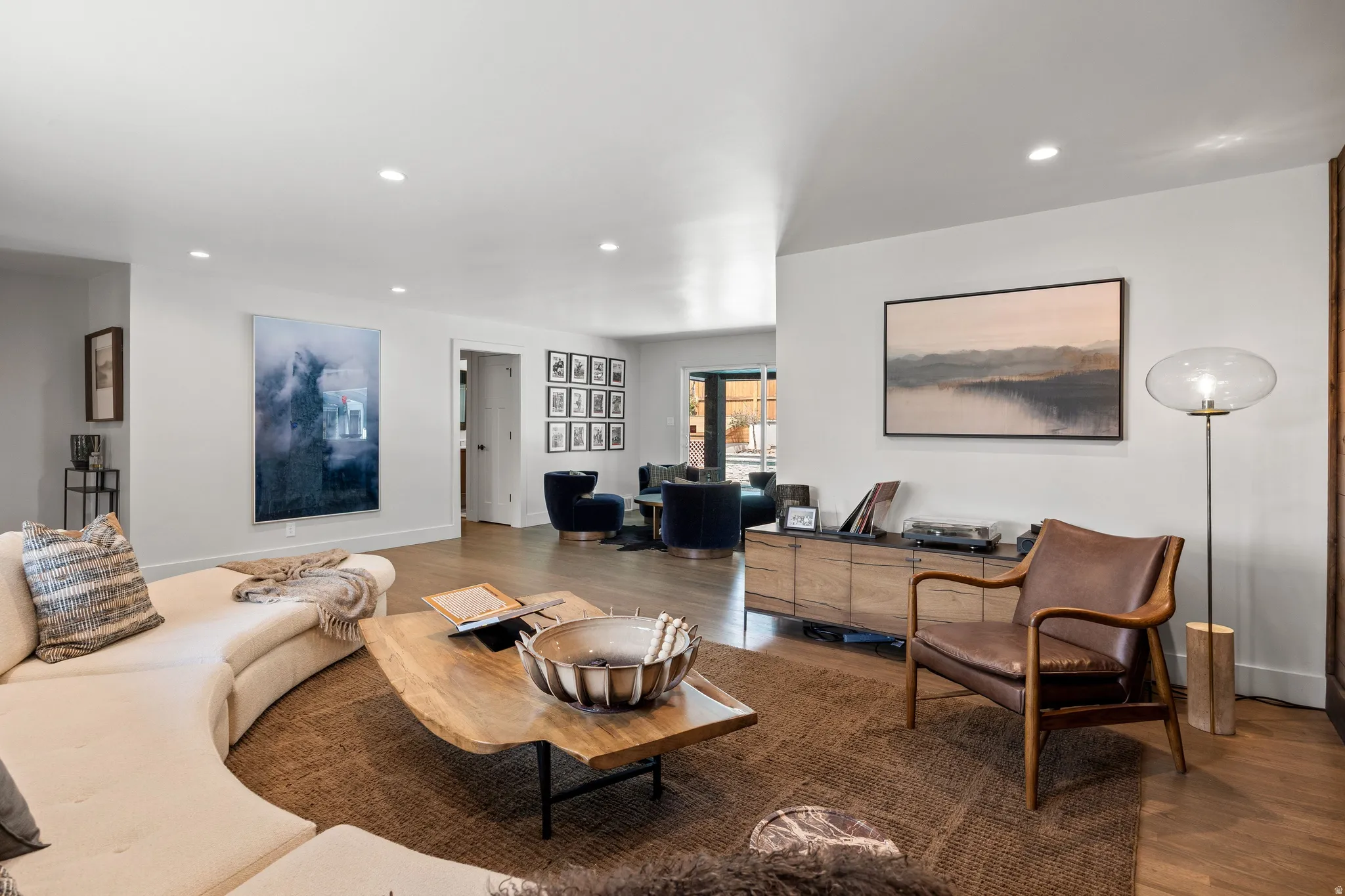 Recessed lighting, wood-finish flooring, and white walls create a bright interior