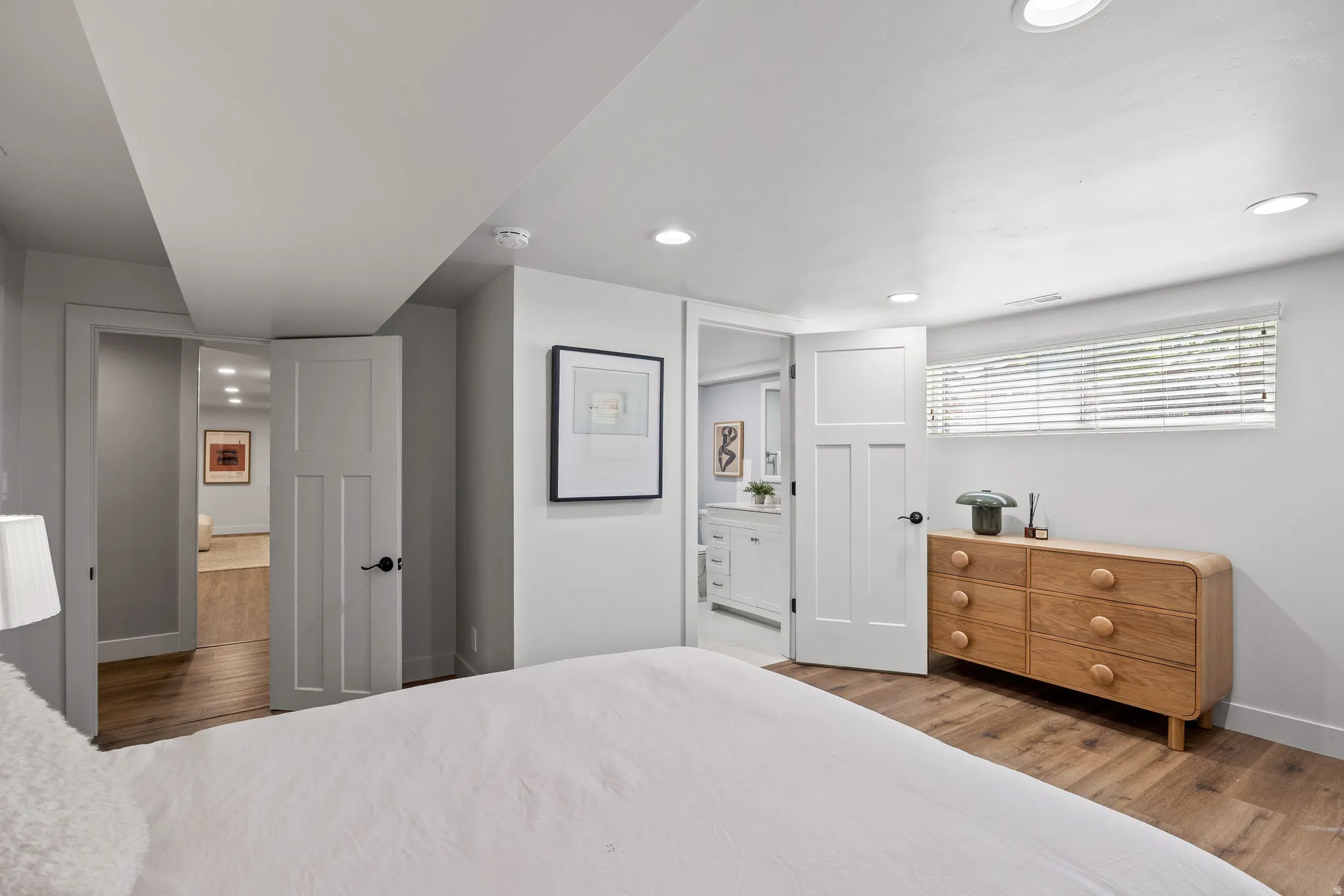 Wood-finish flooring throughout, recessed lighting, and a horizontal window with blinds