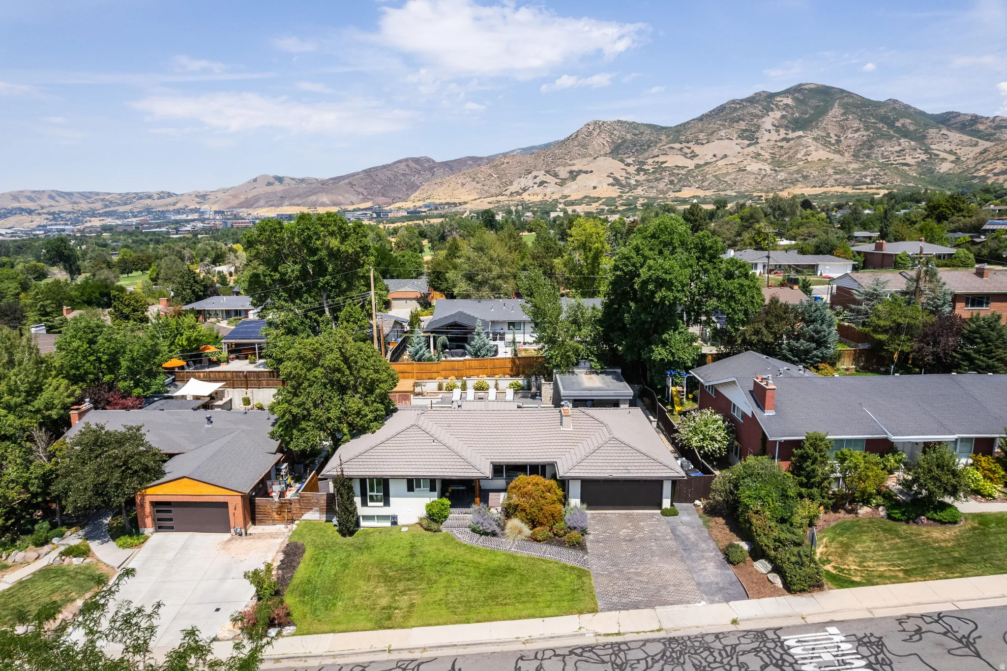 Expansive suburban setting with established trees and mountain backdrop