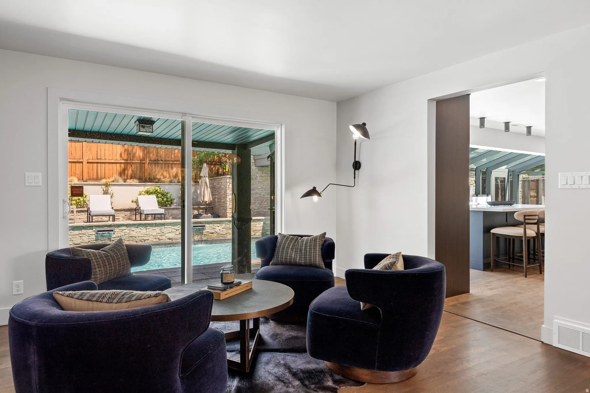 Sliding glass doors leading to a pool, wood-finish flooring, and a pocket door