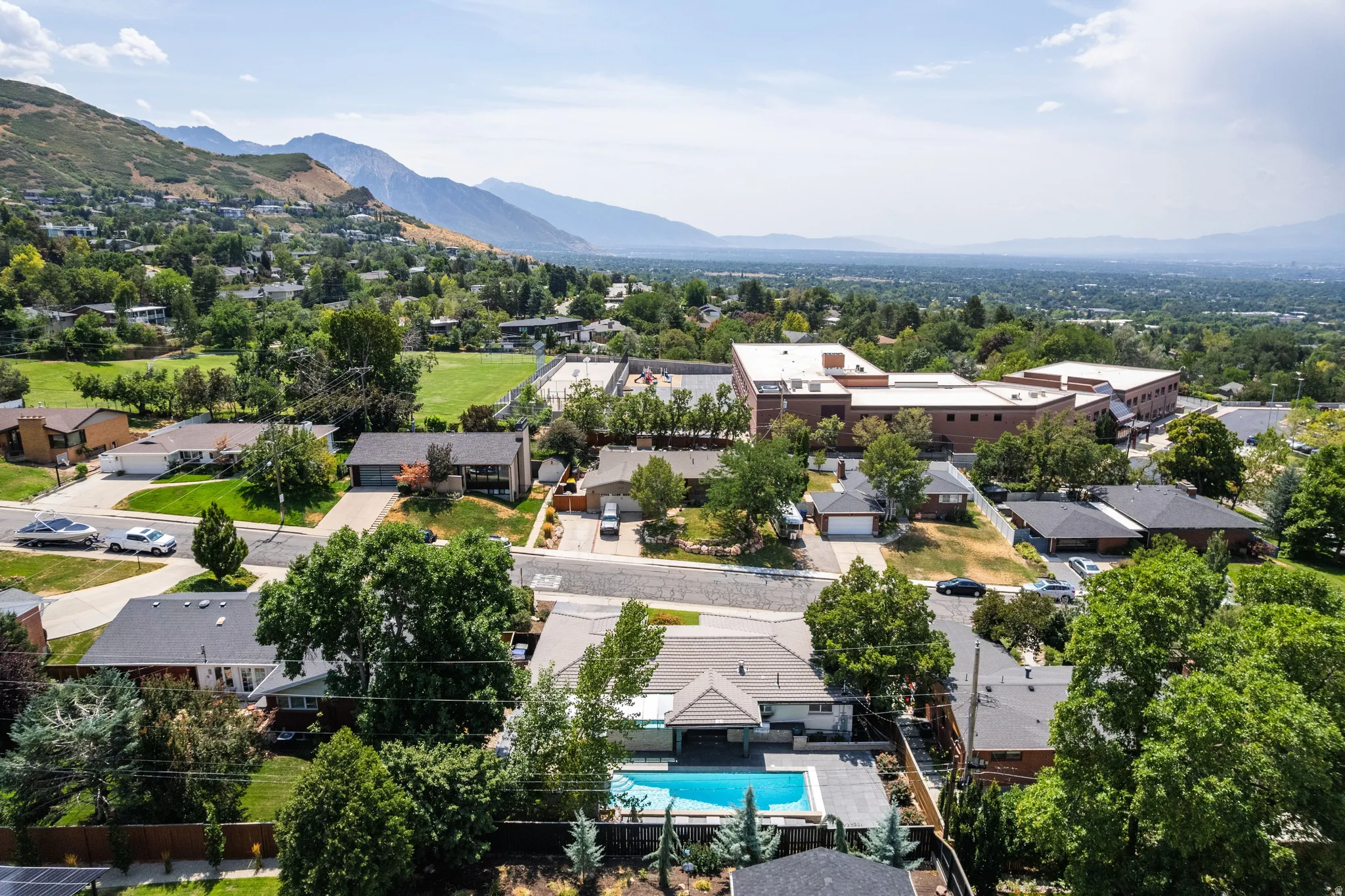 Residential neighborhood with mature trees and a distant mountain backdrop