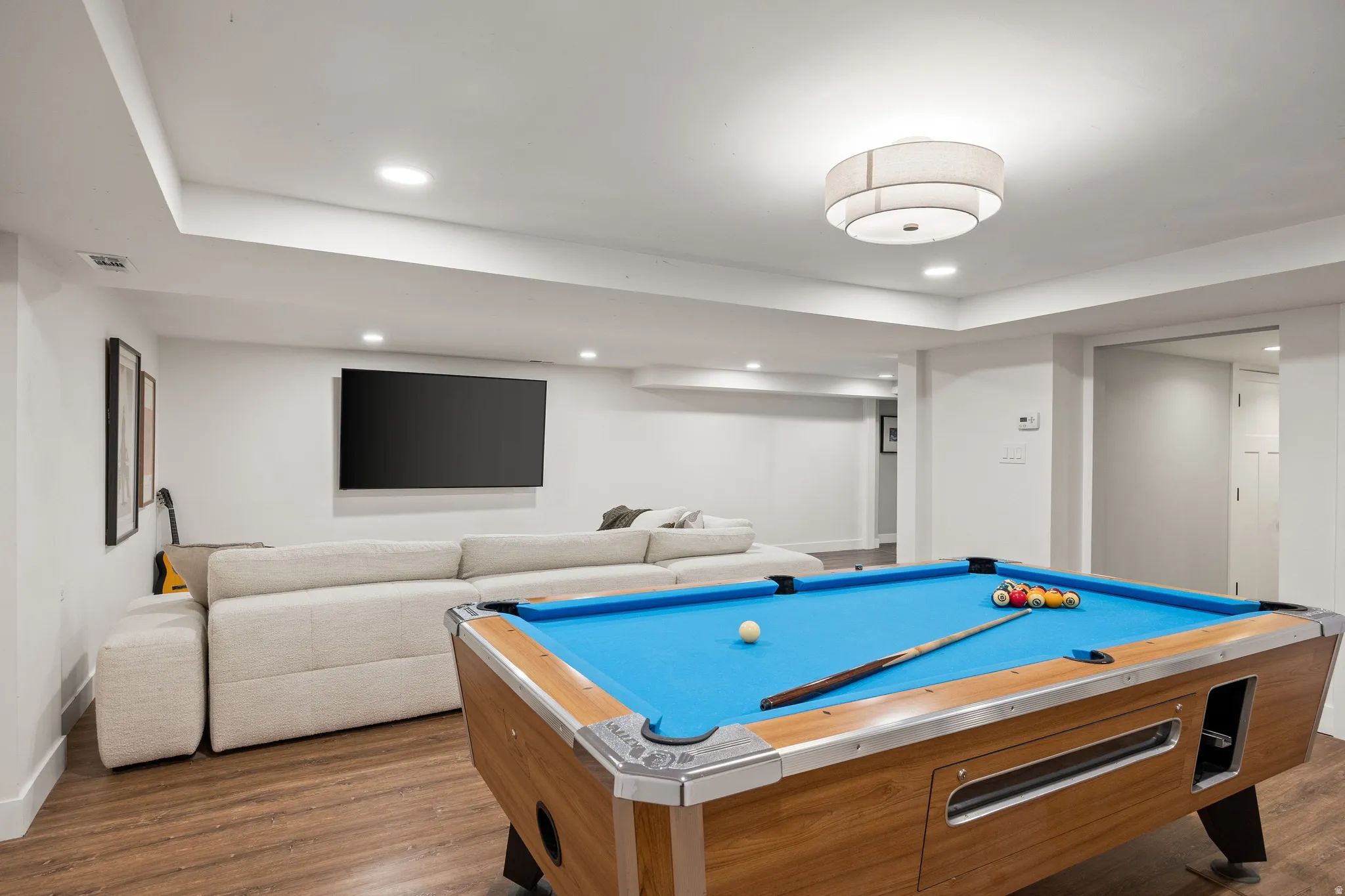 Recessed ceiling lights, wood-finish flooring, and a flush mount light fixture