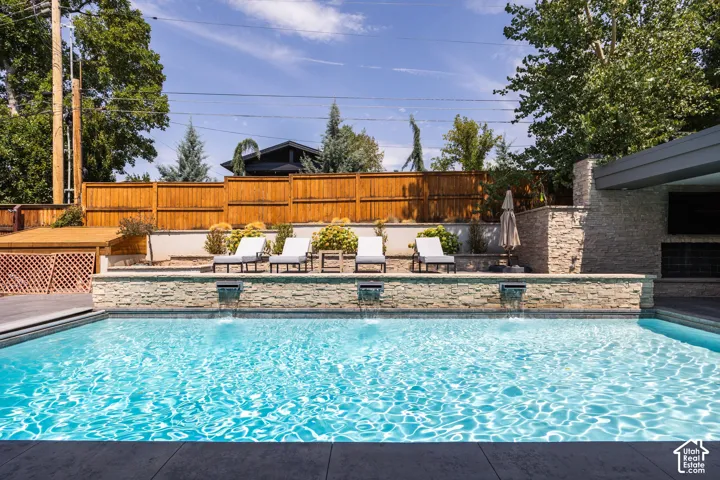 Resort-style pool with integrated water features and stone-clad retaining wall