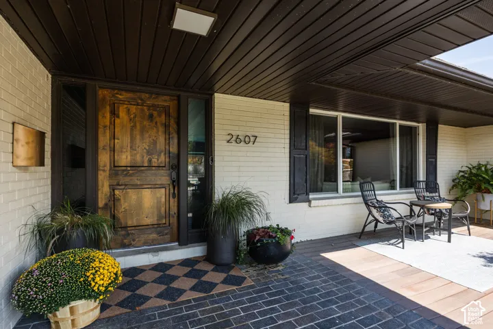 Rich wood paneling overhead, full-light sidelites, and a plank-style wood entry door