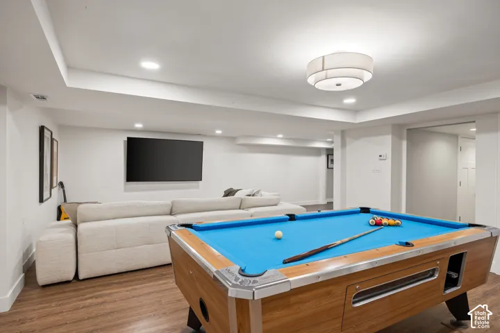 Recessed lighting, wood-finish flooring, and a contemporary flush-mount ceiling fixture