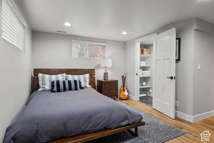 Wood-finish flooring, recessed lighting, and a built-in closet with shelving