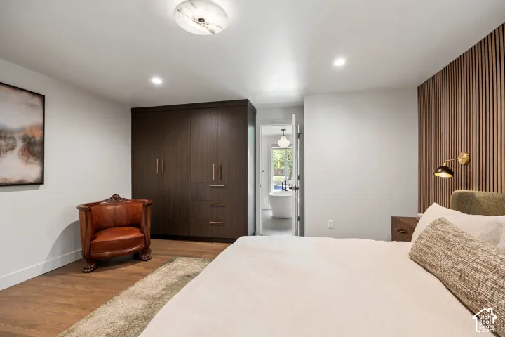 Wood-finish flooring, recessed lighting, and a built-in wardrobe with dark wood-finish cabinetry