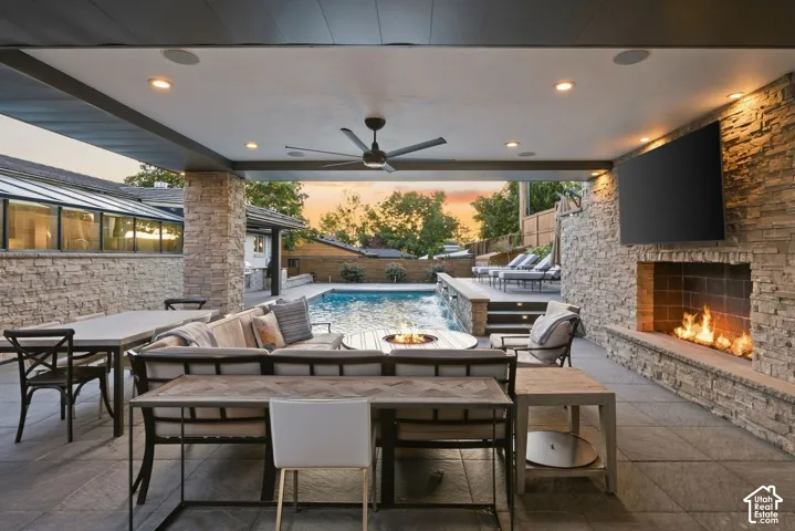 Covered patio with stone-clad fireplace and integrated television