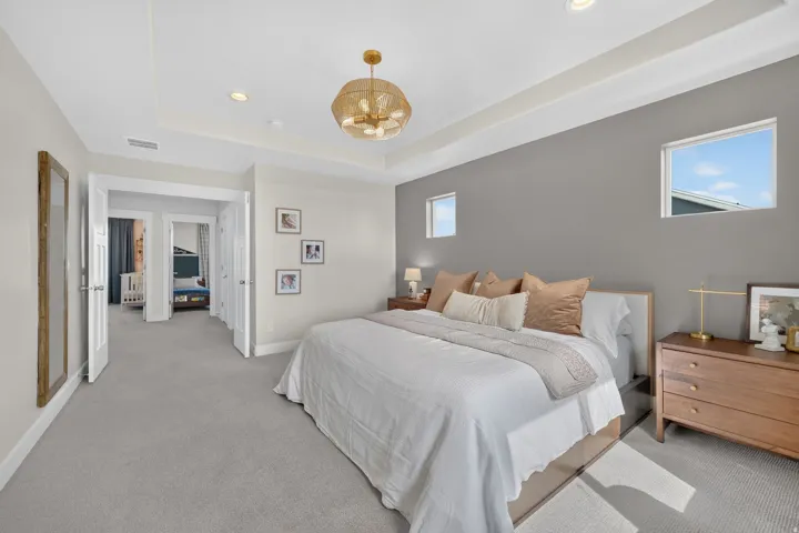 Tray ceiling with recessed lighting, integrated ceiling light fixture, two windows, and light gray wall paint