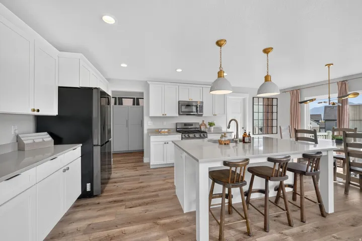 Kitchen featuring white cabinetry, light countertops, wood-finish flooring, recessed lighting, and a kitchen island with pendant lighting