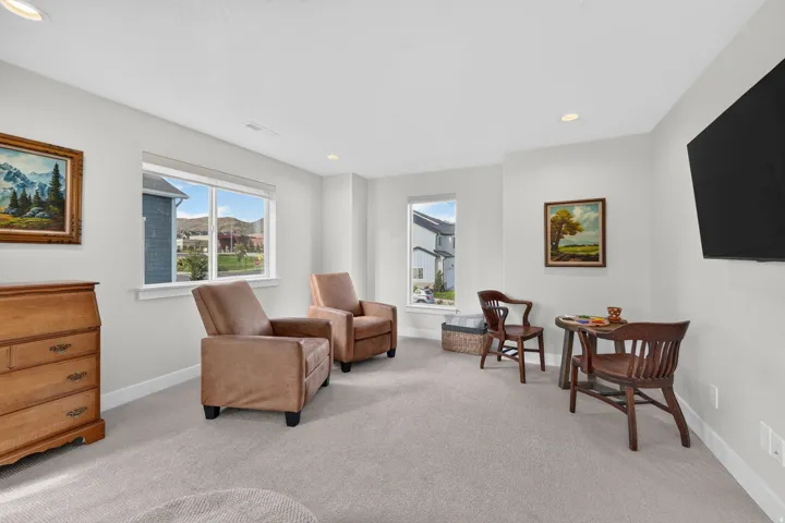 Recessed lighting illuminates the carpeted floor and light-toned walls