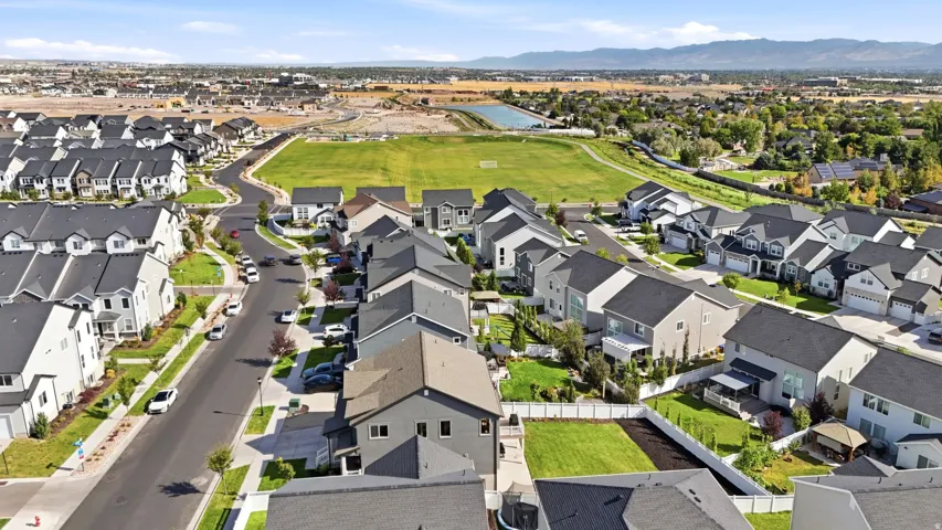 Residential development with a paved street, manicured lawns, and varied architectural styles