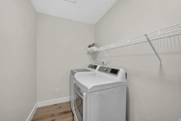 Laundry area with wood-finish flooring and integrated wire shelving