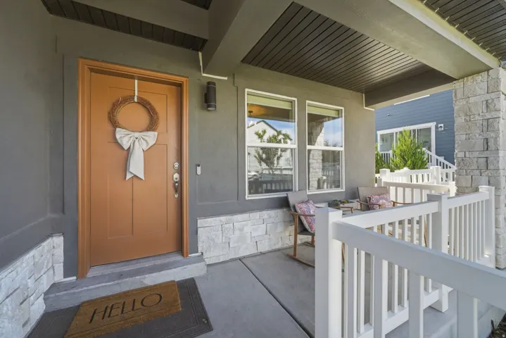 Covered porch featuring stone veneer accents, multi-pane windows, and a wood-paneled ceiling