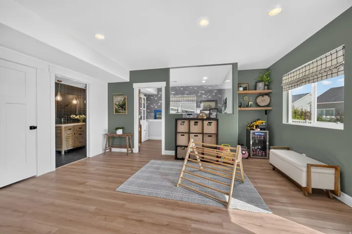 Wood-finish flooring throughout, recessed lighting, and a window with a roller shade