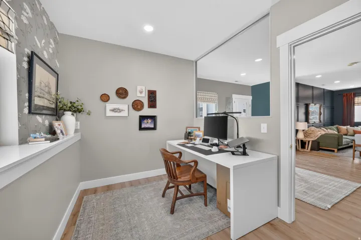 Wood-finish flooring, recessed lighting, and a white built-in desk