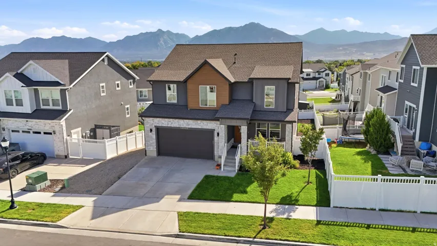 Contemporary two-story residence featuring a dark gray and brown facade with stone accents