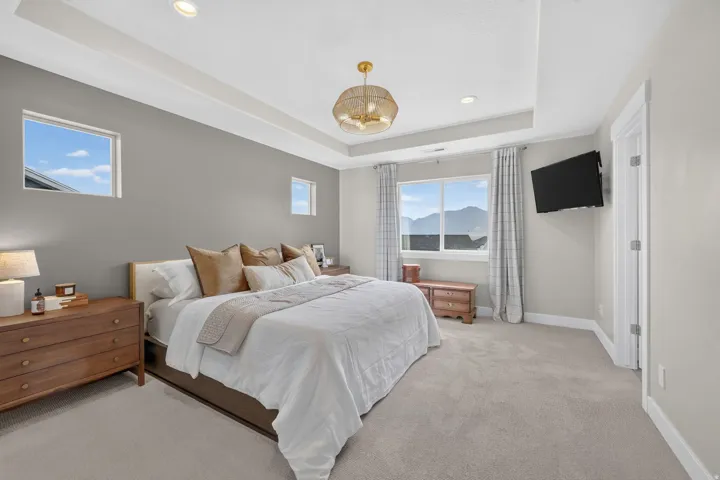 Recessed lighting, tray ceiling, large window, additional windows, and a ceiling-mounted light fixture