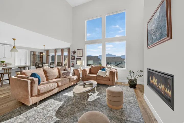 Vaulted ceilings, expansive windows, built-in fireplace, wood-finish flooring, open-concept layout