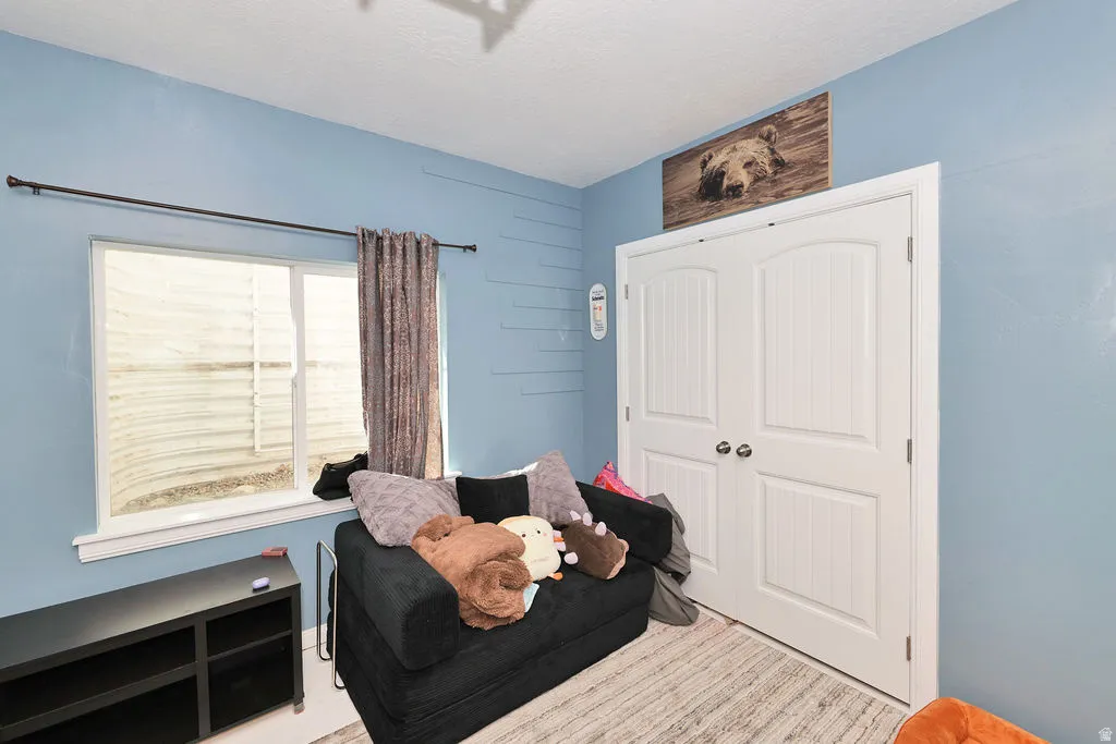 White framed window, white bi-fold closet doors, and light-colored flooring