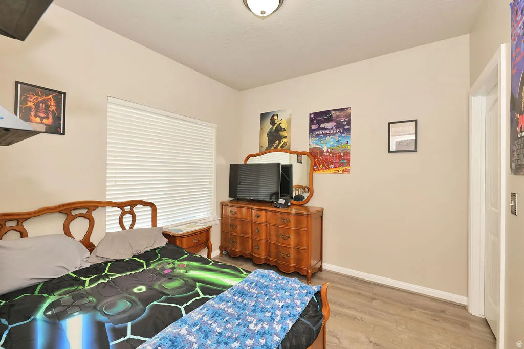 Neutral wall color, wood-finish flooring, and a ceiling-mounted light fixture