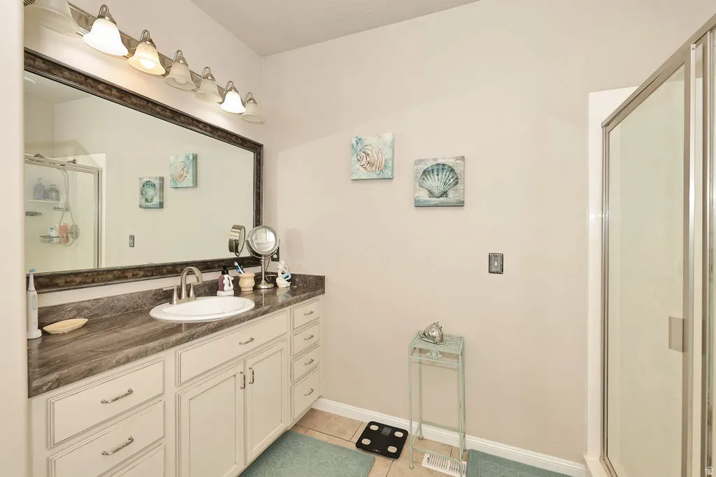 Vanity with an integrated sink, wood-finish countertop, white cabinetry, and brushed nickel hardware