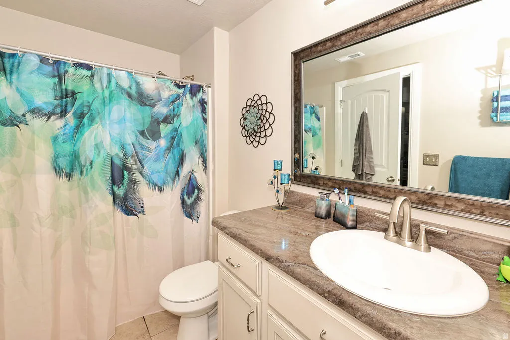 Vanity with an oval sink, brushed nickel faucet, and a large framed mirror
