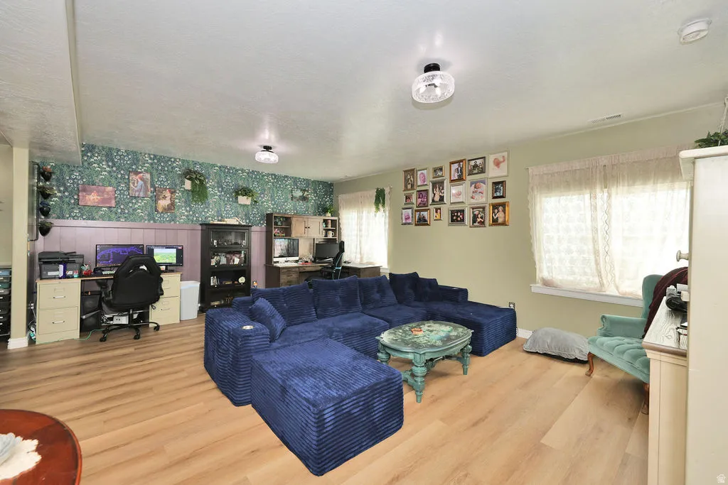 Wood-finish flooring throughout, paired with a patterned accent wall