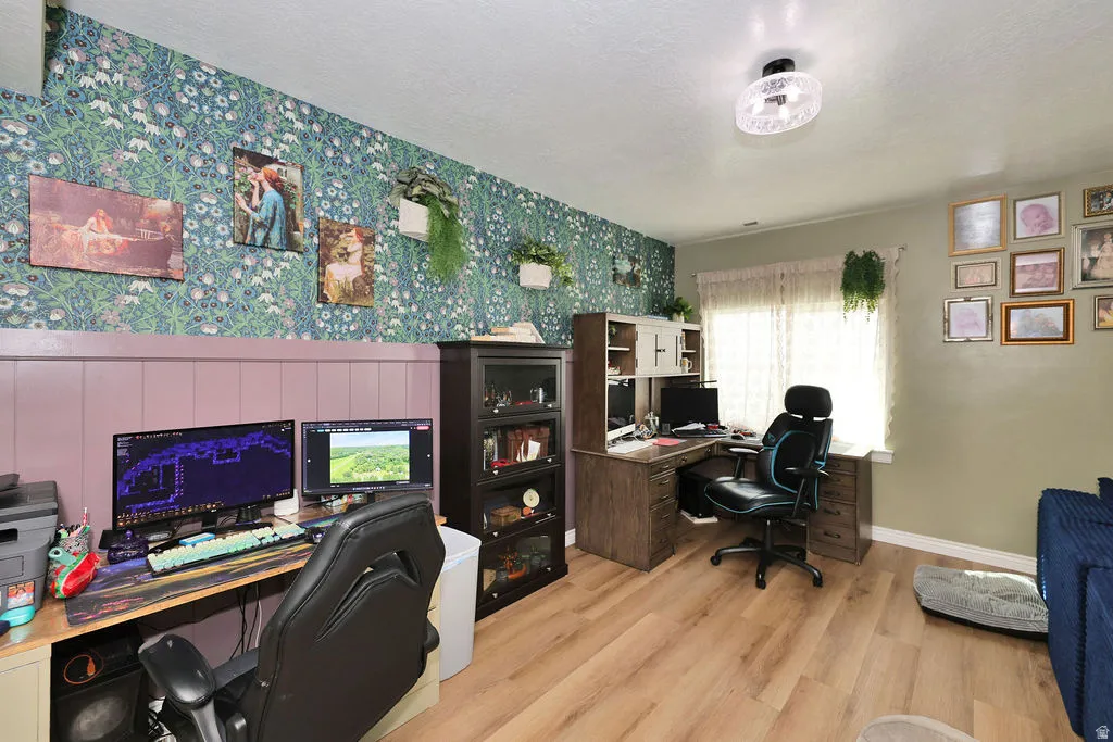 Wood-finish flooring, patterned accent wall, built-in desk, built-in shelving, flush-mount ceiling light