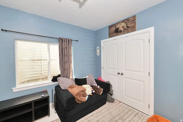 White framed window, white bi-fold closet doors, and light-colored flooring