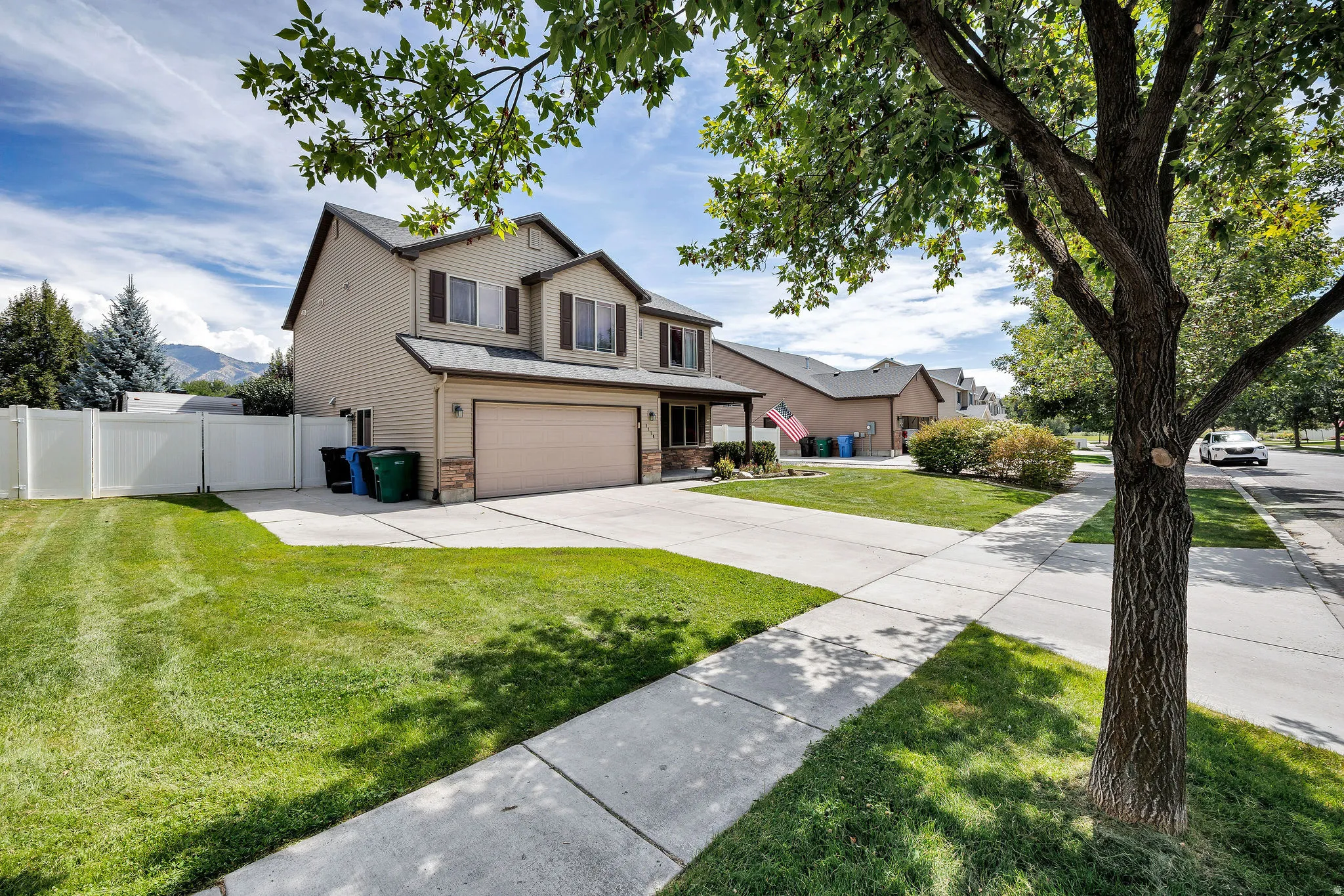 Two-story residence with a two-car garage, stone façade accents, and a fenced backyard