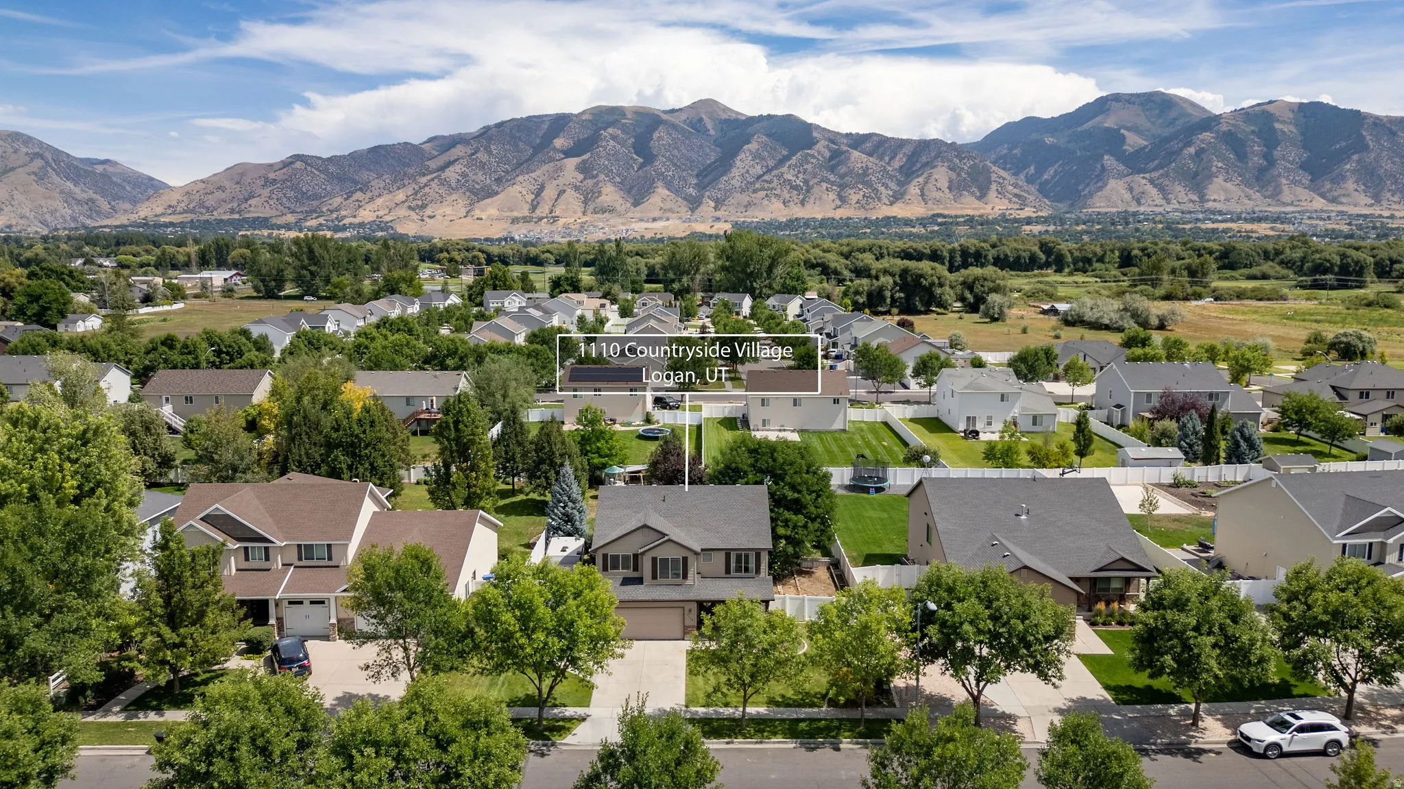 Suburban setting with mountain backdrop and mature trees