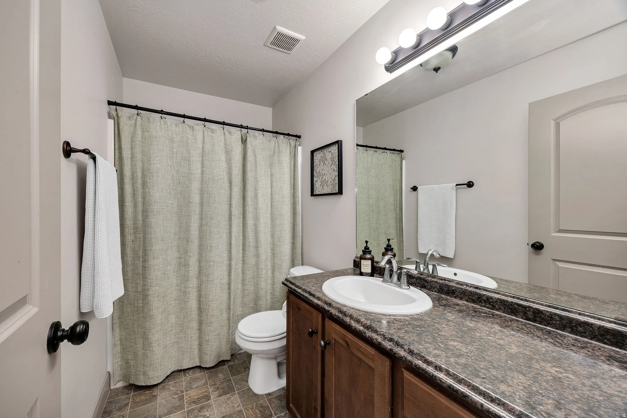 Bathroom with a single vanity, integrated sink, and an expansive mirror