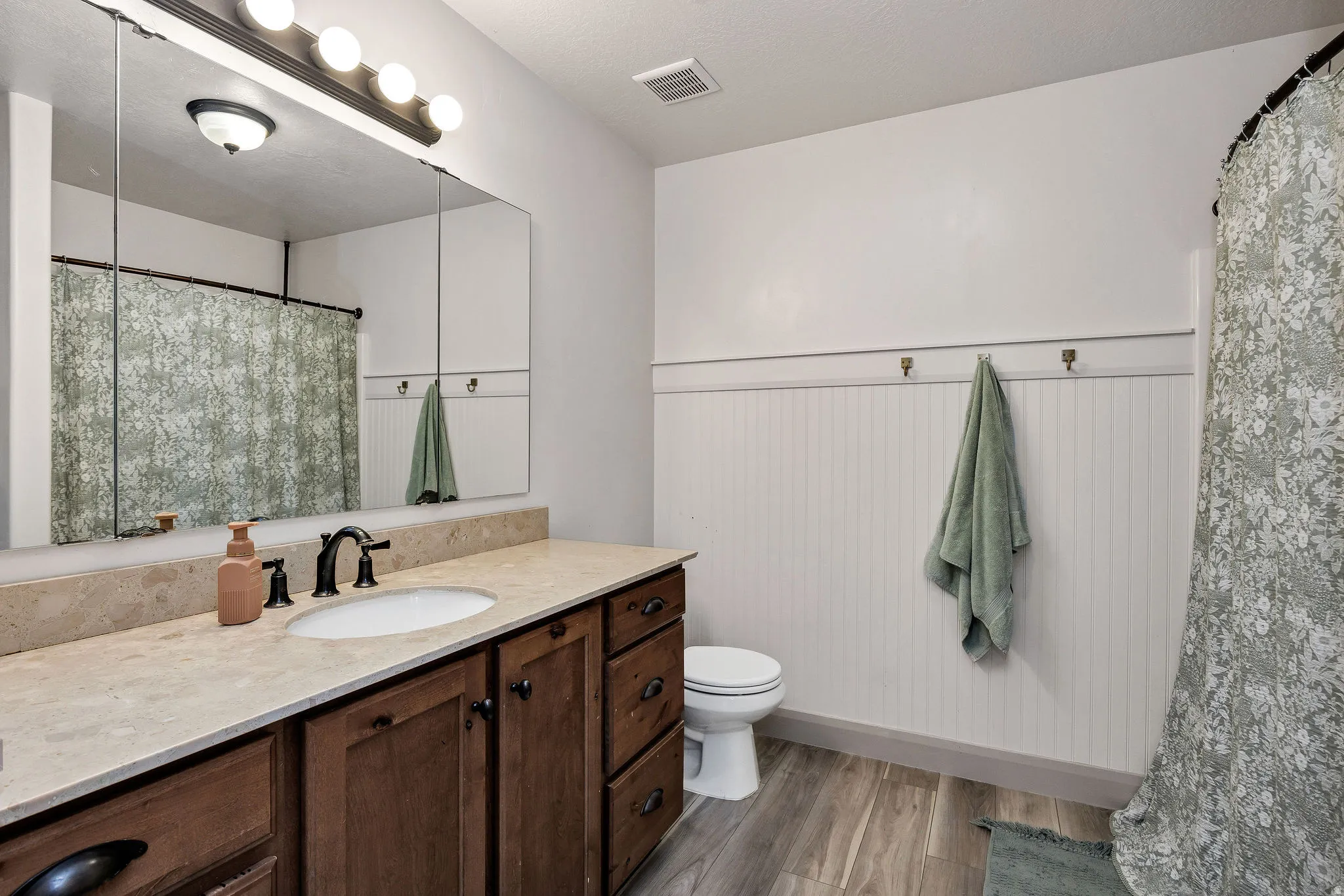 Vanity with a light-colored countertop, dark wood-finish cabinetry, and a single basin sink