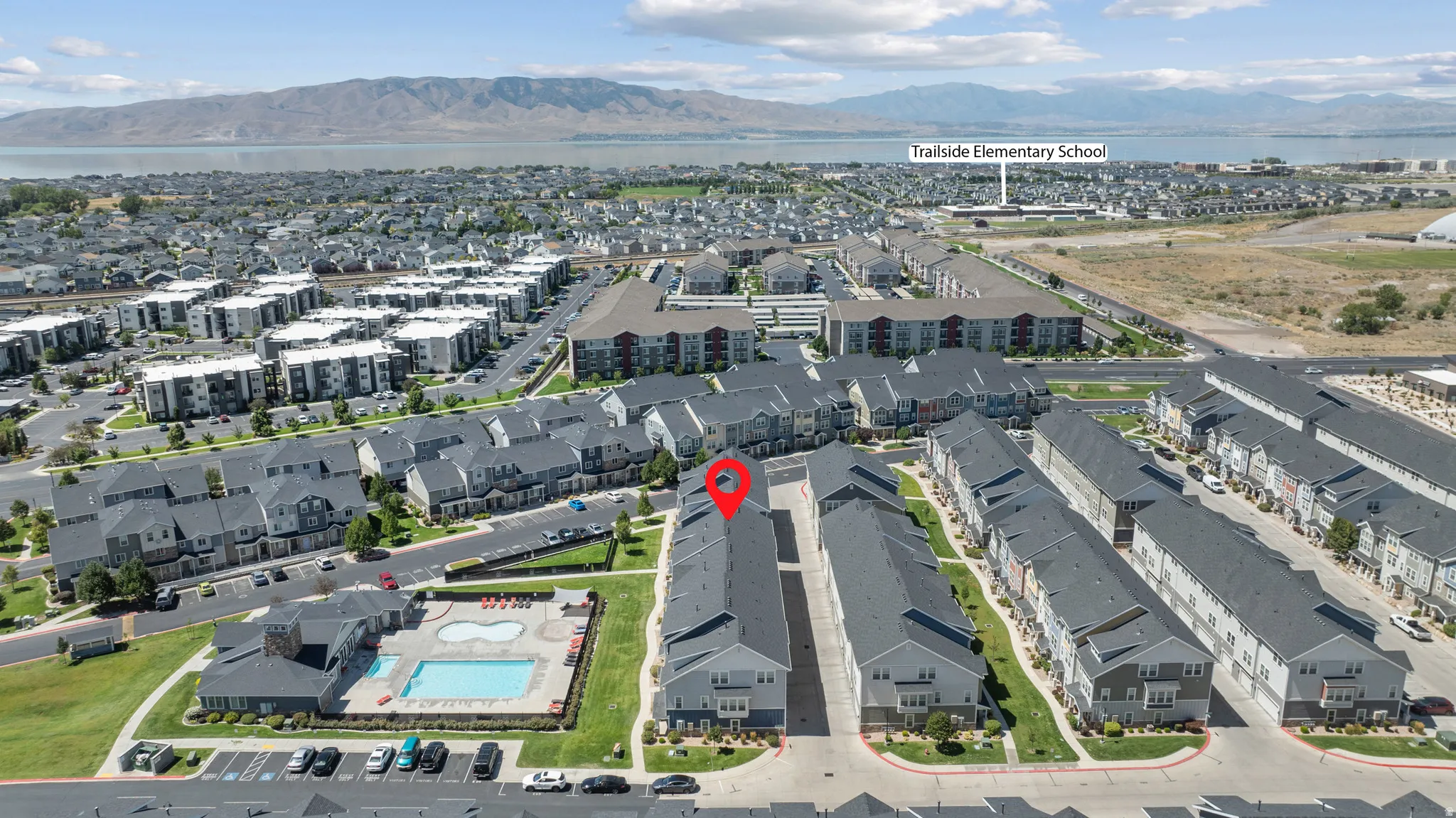 Aerial perspective of a multi-unit residential development with a community pool and adjacent clubhouse